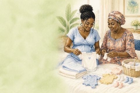 Deux femmes plient ensemble un trousseau de vêtements de naissance